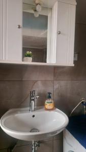 a bathroom sink with a bottle of soap on it at Poly Nest House in Polychrono