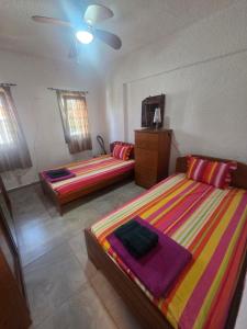 a bedroom with two beds and a dresser in it at Poly Nest House in Polychrono