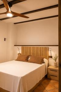 a bedroom with a bed with a wooden headboard at Alojamientos El Cañico in Moratalla