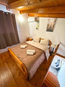 a bedroom with a large bed with two towels on it at Seafront blue in Áyios Spirídhon