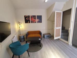 a living room with a chair and a stair case at Authentique Maison de Pêcheur Le Refuge in Le Tréport