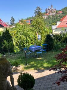 a table and chairs in a garden with a castle at Castrum Visum Wernigerode in Wernigerode