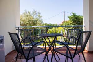 a table and four chairs on a balcony at Yasmin House in Perdika