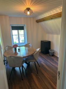 a dining room with a wooden table and chairs at Op t hiem in Nes