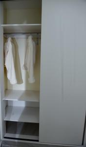 a closet with white clothes hanging in it at comfystdngong in Nairobi