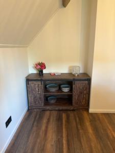 a room with a wooden cabinet with flowers on it at Op t hiem in Nes