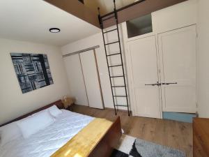 a bedroom with a bed and a ladder in it at Authentique Maison de Pêcheur Le Refuge in Le Tréport