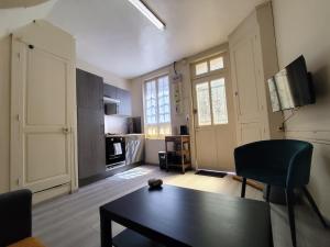 a living room with a table and a kitchen at Authentique Maison de Pêcheur Le Refuge in Le Tréport