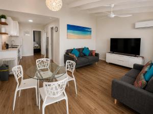 a living room with a couch and a table and chairs at West Beach Lagoon 123 - Location & Views!!! in Perth