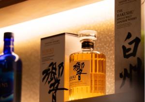 a bottle of whisky on a shelf next to a box at nozawasnow in Nozawa Onsen