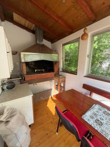 a kitchen with a dining table and a stove at Boracko jezero vikendica Ka&No in Konjic