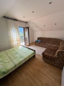a living room with a couch and a bed at Boracko jezero vikendica Ka&No in Konjic
