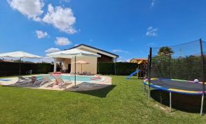 a backyard with a pool with a slide and a playground at Villa Posta Vecchia in Loreo