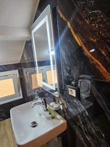 a bathroom with a sink and a mirror at Vila Astrit in Fier