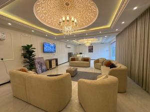 a living room with couches and a chandelier at شاليهات Luma الفندقية in Bisha Airport