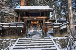a temple in the snow with snow on the stairs at nozawasnow in Nozawa Onsen