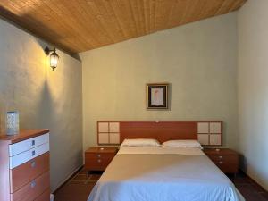 a bedroom with a large bed and a dresser at Refugio de Montaña "El Caroche" Alojamiento entero in Enguera