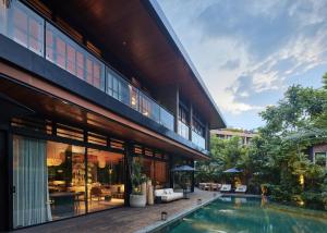 an external view of a building with a swimming pool at Villa Suki in Canggu