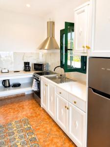 a kitchen with white cabinets and a sink at Ostria Beach House in Órmos Marathokámpou +13 photos