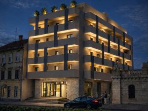 a building with a car parked in front of it at Sunday Residence Split in Split