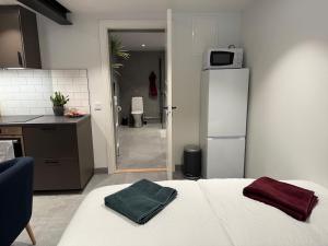 a kitchen with a bed and a refrigerator with two towels at Cozy Modern Basement in Rättvik in Rättvik