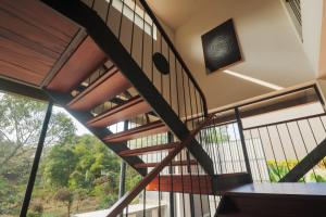 a spiral staircase in a house with a large window at Kayn by spynora in Vythiri