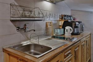 a kitchen with a stainless steel sink and a counter at Góralski Domek Waluś Zakopane - ŚCISŁE CENTRUM - Jedyny domek na Krupówkach in Zakopane