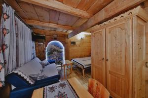 a room with a bed and a chair in a cabin at Góralski Domek Waluś Zakopane - ŚCISŁE CENTRUM - Jedyny domek na Krupówkach in Zakopane +15 photos