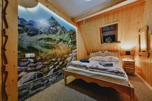 a bedroom with a large painting on the wall at Góralski Domek Waluś Zakopane - ŚCISŁE CENTRUM - Jedyny domek na Krupówkach in Zakopane