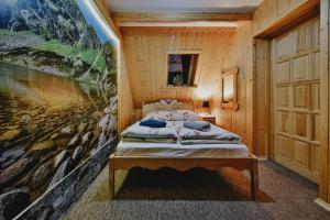 a bedroom with a bed in a wooden cabin at Góralski Domek Waluś Zakopane - ŚCISŁE CENTRUM - Jedyny domek na Krupówkach in Zakopane