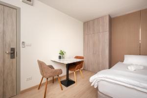 a bedroom with a bed and a table and chairs at 101 Residence in Amphoe Phra Khanong