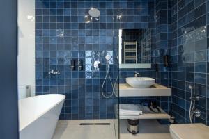 a blue tiled bathroom with a tub and a sink at M&N Hotel in Tbilisi City +90 photos