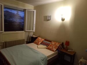 a small bedroom with a bed and a window at Maison entière Garage et parking in Montluçon