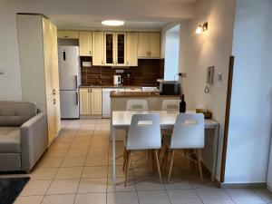 a kitchen with a table and white chairs in a room at Chalupa Marie in Radimovice u Želcě