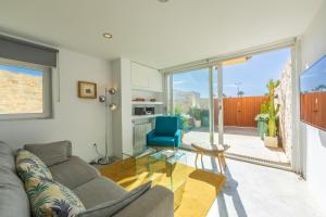 a living room with a gray couch and a blue chair at Caracolas Luxury House in Tarifa