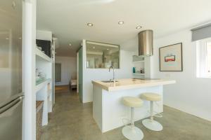 a kitchen with a sink and two stools at Caracolas Luxury House in Tarifa +42 photos