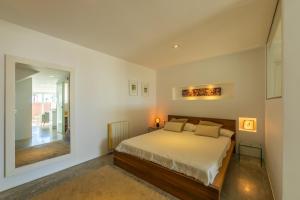 a bedroom with a bed and a large mirror at Caracolas Luxury House in Tarifa