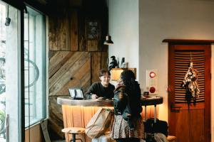 a man and a woman sitting at a bar in a room at Len Kyoto Kawaramachi in Kyoto
