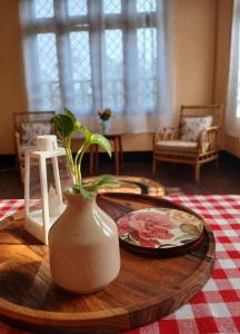 a table with a vase and a plate on a table at sicsac inn in Jorhat +3 photos
