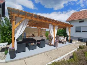 an outdoor patio with a wooden pergola at OAZA Miokus in Miokus