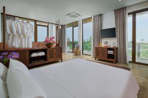 a large bedroom with a large bed and windows at ArtLua Boutique Hotel Tam Coc in Văn Lâm