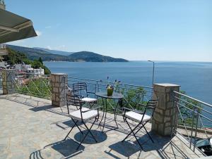 a table and chairs on a balcony overlooking the water at Sunrise Suite in Kavála