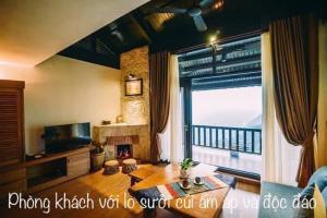 a living room with a fireplace and a large window at Sapa mến khách sapa jade hill in Lao Cai