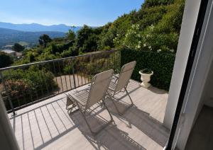 two chairs sitting on a balcony with a view at Villa Muvra in Ajaccio +1 photo