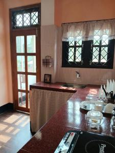 a kitchen with a counter top and a window at sicsac inn in Jorhat