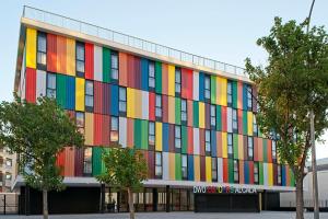 a building with a colorful facade with trees in front at DWO Colours Alcalá in Madrid