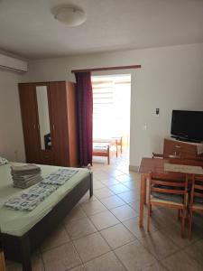 a bedroom with a bed and a table and a television at Apartments Alma in Orebić