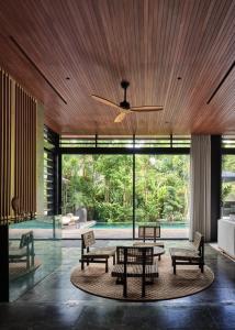 a living room with a table and chairs and a pool at Villa Suki in Canggu