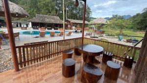 a balcony with a table and stools next to a pool at Loop Tribe - Social Hostel in Ha Giang