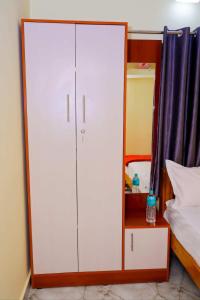 a large white cabinet sitting next to a bed at Loki guest House in Chikmagalūr